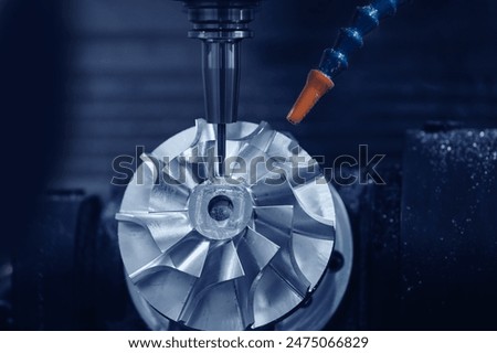 Industry CNC milling machine process cutting turbine impeller and blades, blue light toning.