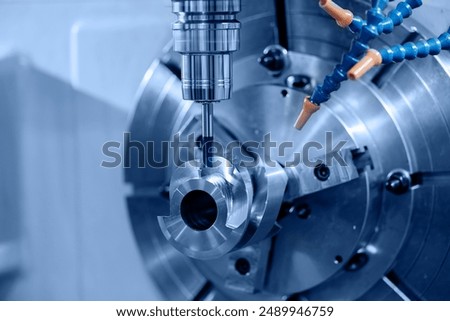 Industry CNC milling machine process cutting turbine impeller and blades, blue light toning.