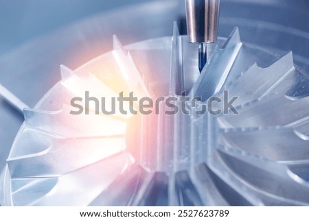 Industry CNC milling machine process cutting turbine impeller and blades, blue light toning.