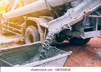 Industry Concept. Concrete Mixing Truck Service Pouring Cement In Site Building Construction On Daytime. Cement Was Poured Into A Wheelchair Or Cement Trolley To Make The Floor.