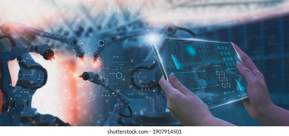 Industry engineer in factory,using smart tablet glass device,control automated robot arm machine learning operation,concept business and industry 4.0,Artificial intelligence or AI,with 5G network - Shutterstock ID 1907914501