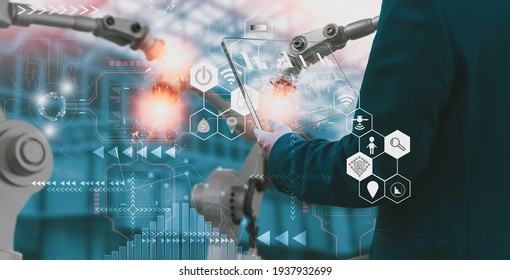Industry engineer in factory,using smart tablet glass device,control automated robot arm machine learning operation,concept business and industry 4.0,Artificial intelligence or AI,with 5G network - Shutterstock ID 1937932699