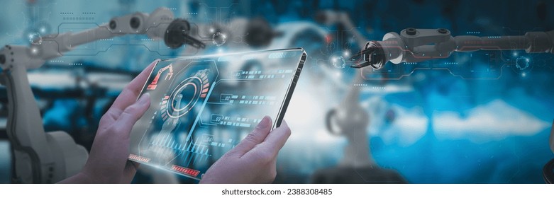 Industry engineer in factory,using smart tablet glass device,control automated robot arm machine learning operation,concept business and industry 4.0,Artificial intelligence or AI,with 5G network