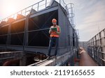 Industry engineer under checking the industry cooling tower air conditioner is water cooling tower air chiller HVAC of large industrial building to control air system.