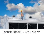 Industry engineer under checking the industry cooling tower air conditioner is water cooling tower air chiller HVAC of large industrial building to control air system.