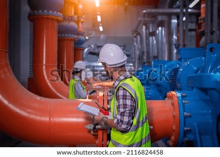 Industry engineer under checking the industry cooling tower air conditioner is water cooling tower air chiller HVAC of large industrial building to control air system.