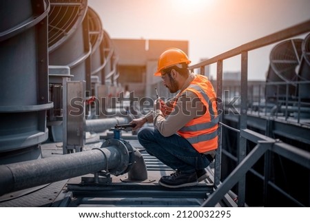 Industry engineer under checking the industry cooling tower air conditioner is water cooling tower air chiller HVAC of large industrial building to control air system.