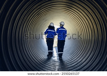 Industry Engineers Walking Inside Circular water Pipe. Engineering or Worker inspection pipe circular. Checking Construction of the water, Oil Natural Gas and fuels Transport Pipeline.