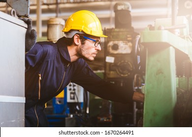 Industry Factory Maintenance Engineer Wearing Uniform And Safety Helmet Under Inspection And Checking Production Process On Factory Station On Machinery. Industry, Engineer, Construction Concept.