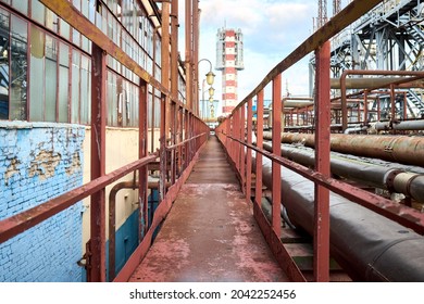 Industry highway walkway platform with grate and handrail on petrochemical plant factory with lighting masts and explosion-proof fireproof design rusty retro style lanterns and urea tower granulator.