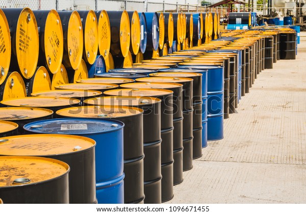 Industry oil barrels or chemical\
drums stacked up.container of  barrels of hydrocarbons.hazardous\
waste of black and blue tank oil.Stack Of Oil barrels in\
plant.