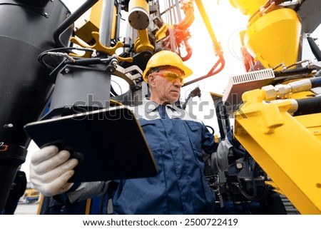 Industry operator use computer tablet for control drilling rig for exploration of minerals for oil, gas and artisan water.