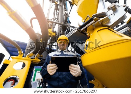 Industry operator use computer tablet for control drilling rig for exploration of minerals for oil, gas and artisan water.