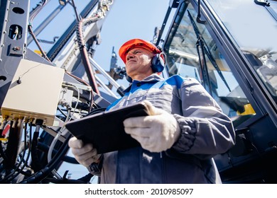 Industry operator use mobile tablet for control drilling rig for exploration of minerals for oil, gas and artisan water.
