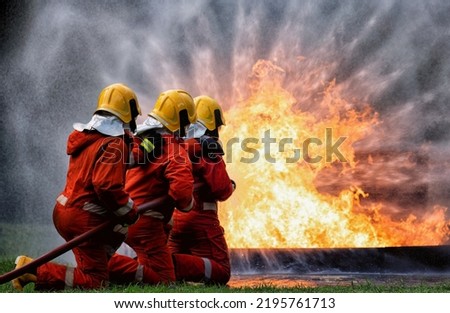 In Industry safety fire fighter team department on  training fight with gas and oil fire by hold hose together spray jet turbulence water and foam to extinguish remove oxygen
