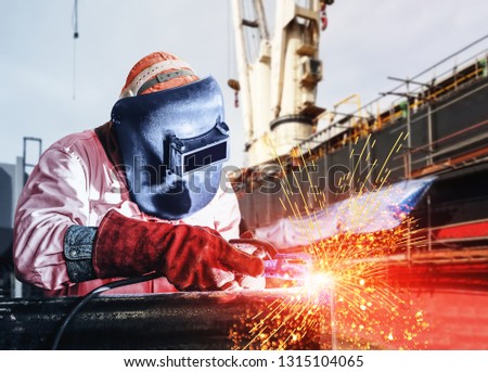  Industry shipbuilding Welder worker and ship repair industry at the factory and floating dock on side shell hull background.