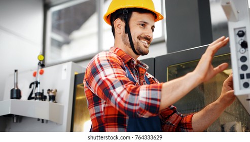 Industry Worker entering data in CNC machine at factory