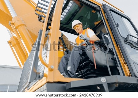 Industry worker portrait. Man driver builder operate crane or excavator at construction site.