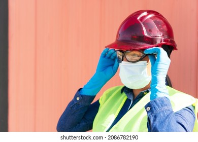 Industry Worker Wearing Protective Mask And Putting On Safety Goggles