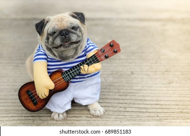 Indy Musician Guitarist pug dog.(Funny pug dog wearing indy musician costume with Ukulele.) - Shutterstock ID 689851183