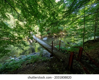 Inelet, Romania - August 11 2021: Bridge over Cerna river on the trail to Ineleț and Scărişoara hamlets. Those are two isolated villages in Cerna Mountains. - Shutterstock ID 2031808820