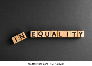 Inequality to equality - word from wooden blocks with letters, economic social inequality concept,  top view on grey background