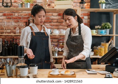 Inexperienced Girl Barista. Angry Owner Of Restaurant Scolding New Employee Behind Bar Counter. Manager Dissatisfied With Waitress's Work Of Making Coffee And Baking Croissant In Modern Cafe Shop.