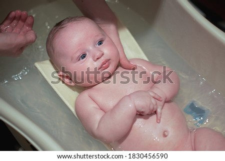 Similar – Newborn in the bathtub with her mother washing her hair