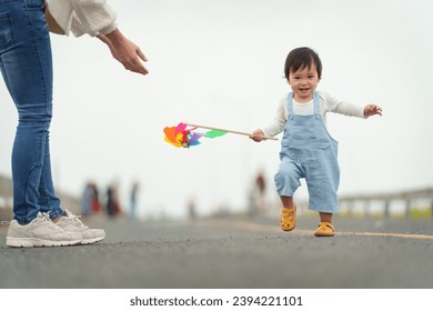 infant baby learn walking first step on a pathway with mother helping - Powered by Shutterstock