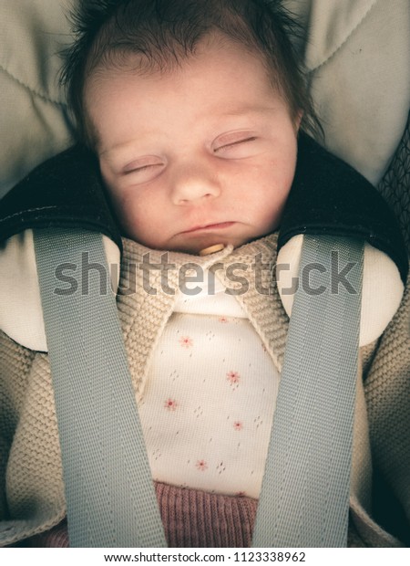 infant baby\
sleeping in car with seatbelt\
on