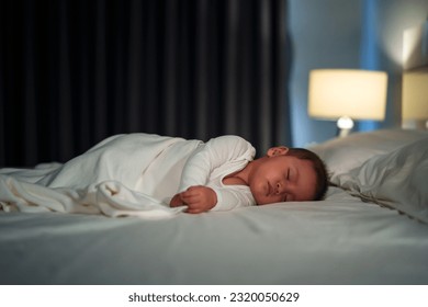 infant baby sleeping on a bed at night - Powered by Shutterstock