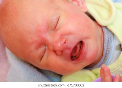 Infant Care, Teething Pain, Colic Ache Concept. Little Newborn Baby Crying In Bed Surrounded With Blankets