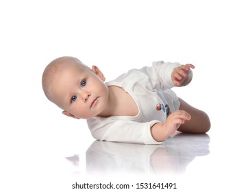 Infant Child Baby Boy Toddler In White Bodysuit White Shirt Is Lying On Its Side, Trying To Roll Over, Held Out His Hand On White Background