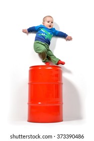 Infant Child Baby Boy Toddler Standing Jumping Scary On Red Barrel Can On A White Background