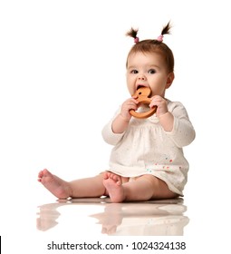 Infant Child Baby Girl Toddler Sitting With Eco Wood Teeth Teether With Bristle Toy Isolated On A White Background