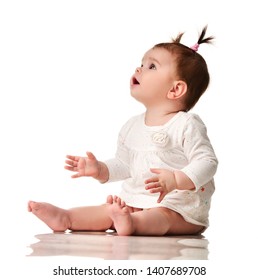 Infant child baby toddler sitting with hand pointing at the corner surprised isolated on a white background