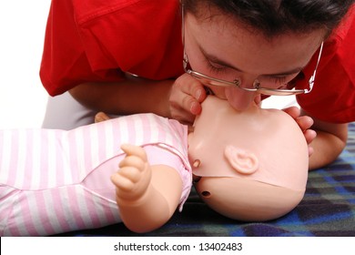 Infant dummy first aid demonstration series - first aid instructor demonstrating artificial respiration - for babies artificial respiration is done through infant's nose and mouth at the same time
