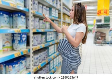 Infant Food Pregnant Woman. Beautiful Pregnancy Woman Shopping Infant Baby Formula Powder On Store Market Background. Shopping Child Food Supermarket Concept