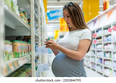 Infant Food Pregnant Woman. Beautiful Pregnancy Woman Shopping Infant Baby Formula Powder On Store Market Background. Shopping Child Food Supermarket Concept