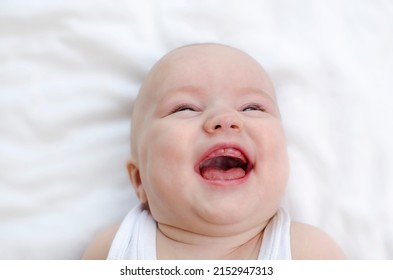 Infant Laughing. Baby Smiling With A Toothless Mouth Close-up. Children Healthcare