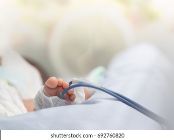 Infant Or Newborn Baby Feet With Pulse Oximeter For Determine Oxygen Saturation In Baby's Blood, In Incubator At Intensive Room Care In The Hospital After Delivery