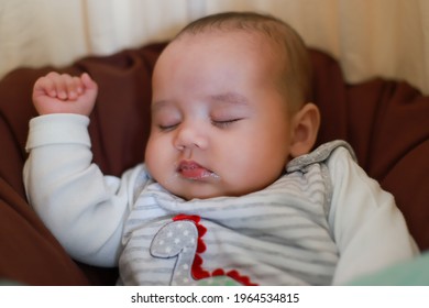 Infant Newborn Sleeping In Bed With Dirty Mouth Vomiting. Baby Over Feeding Concept. Mixed Race Asian-German Child About 2-3 Months Old Sleep In Bassinet Bed.