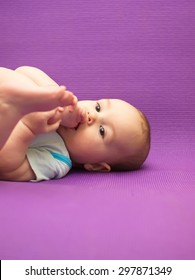 Infant On A Purple Background. Baby On A Purple Background.