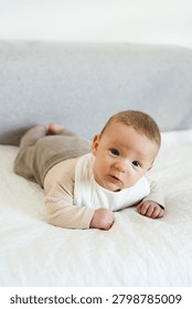 Infant practicing tummy time while lifting and holding the head independently. Early childhood developmental milestone that helps strengthen neck, shoulder, and upper body muscles.