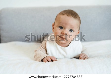 Infant practicing tummy time while lifting and holding the head independently. Early childhood developmental milestone that helps strengthen neck, shoulder, and upper body muscles.