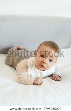 Infant practicing tummy time while lifting and holding the head independently. Early childhood developmental milestone that helps strengthen neck, shoulder, and upper body muscles.