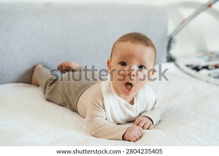 Infant practicing tummy time while lifting and holding the head independently. Early childhood developmental milestone that helps strengthen neck, shoulder, and upper body muscles.