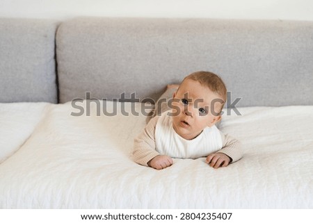 Infant practicing tummy time while lifting and holding the head independently. Early childhood developmental milestone that helps strengthen neck, shoulder, and upper body muscles.