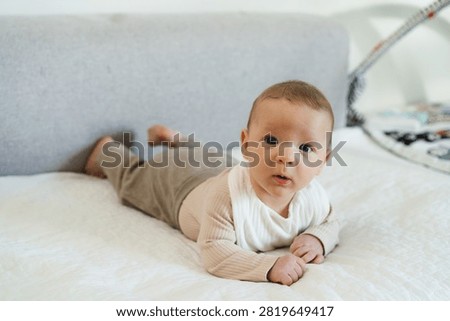 Infant practicing tummy time while lifting and holding the head independently. Early childhood developmental milestone that helps strengthen neck, shoulder, and upper body muscles.