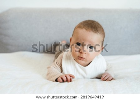 Infant practicing tummy time while lifting and holding the head independently. Early childhood developmental milestone that helps strengthen neck, shoulder, and upper body muscles.